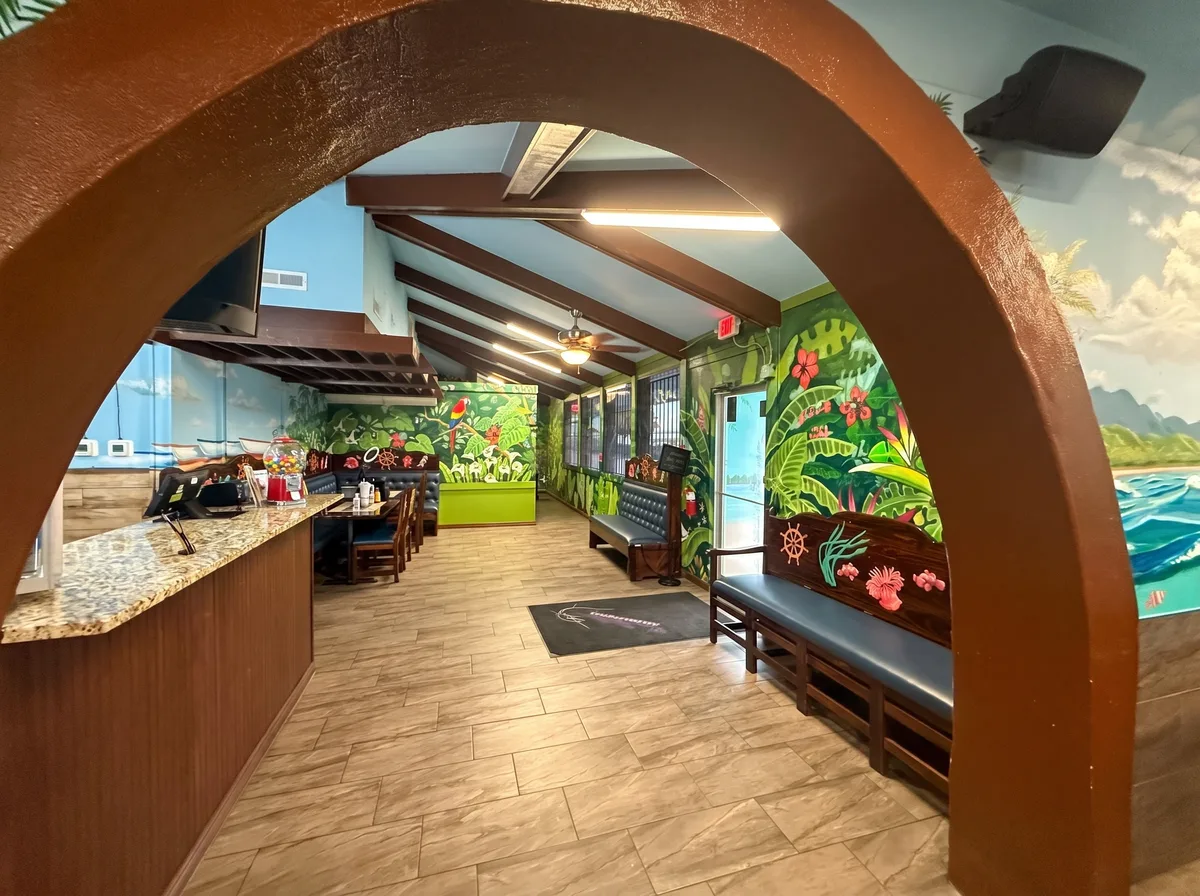 Comedor con arco terracota y mural de selva
